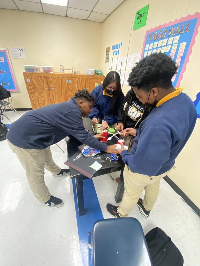 Damorian Matthews, Kimberly Lopez, and Le’Qualin Thomas construct a catapult to project a ping pong ball.
