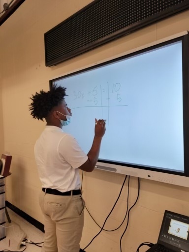 A student writes on a smart board.