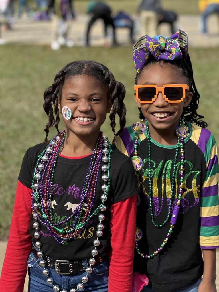 Two smiling children in Mardi Gras garb.