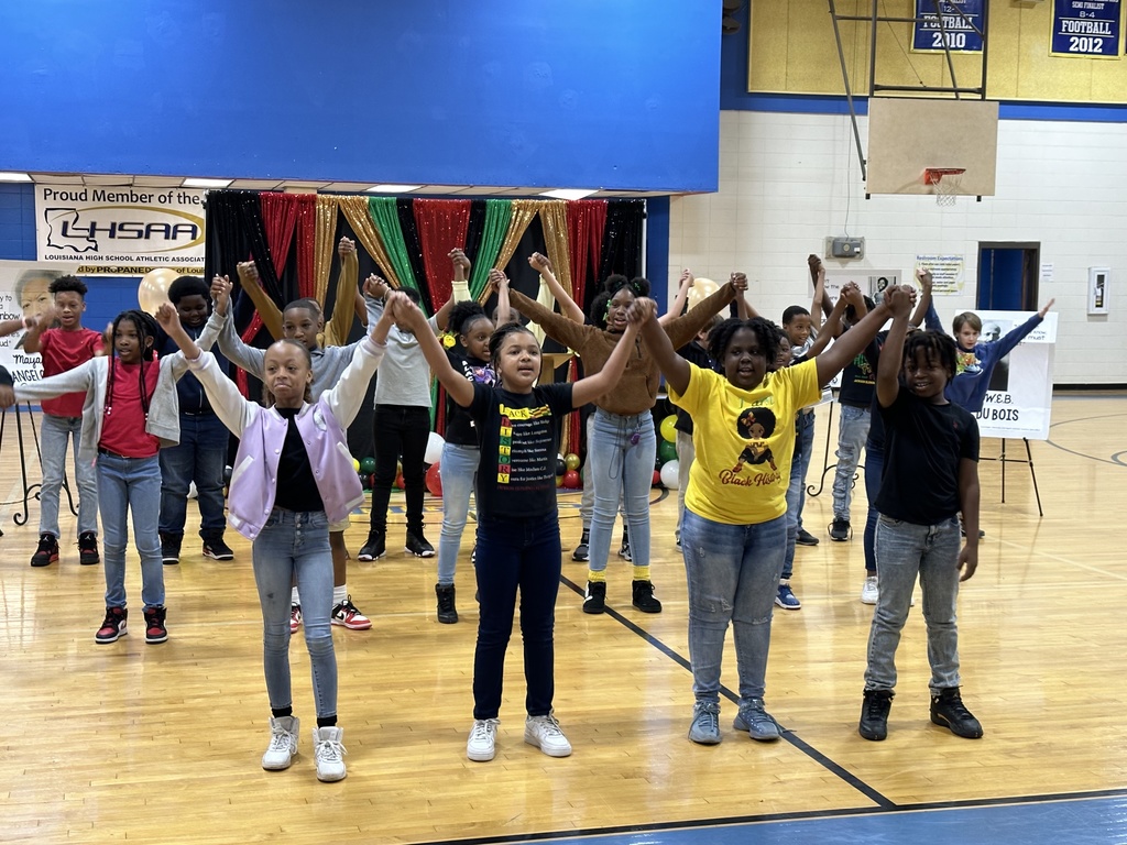 A group of students raise up their arms as they hold hands.