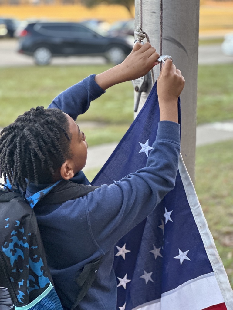 A student clips the American flag to the flag pole.