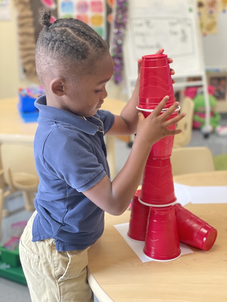 A child focuses on cups he is stacking.