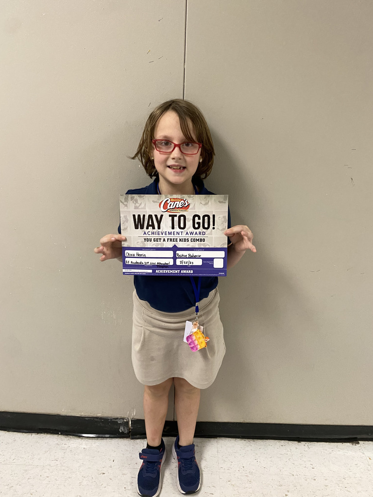 A child in glasses holds up a Cane's certificate.