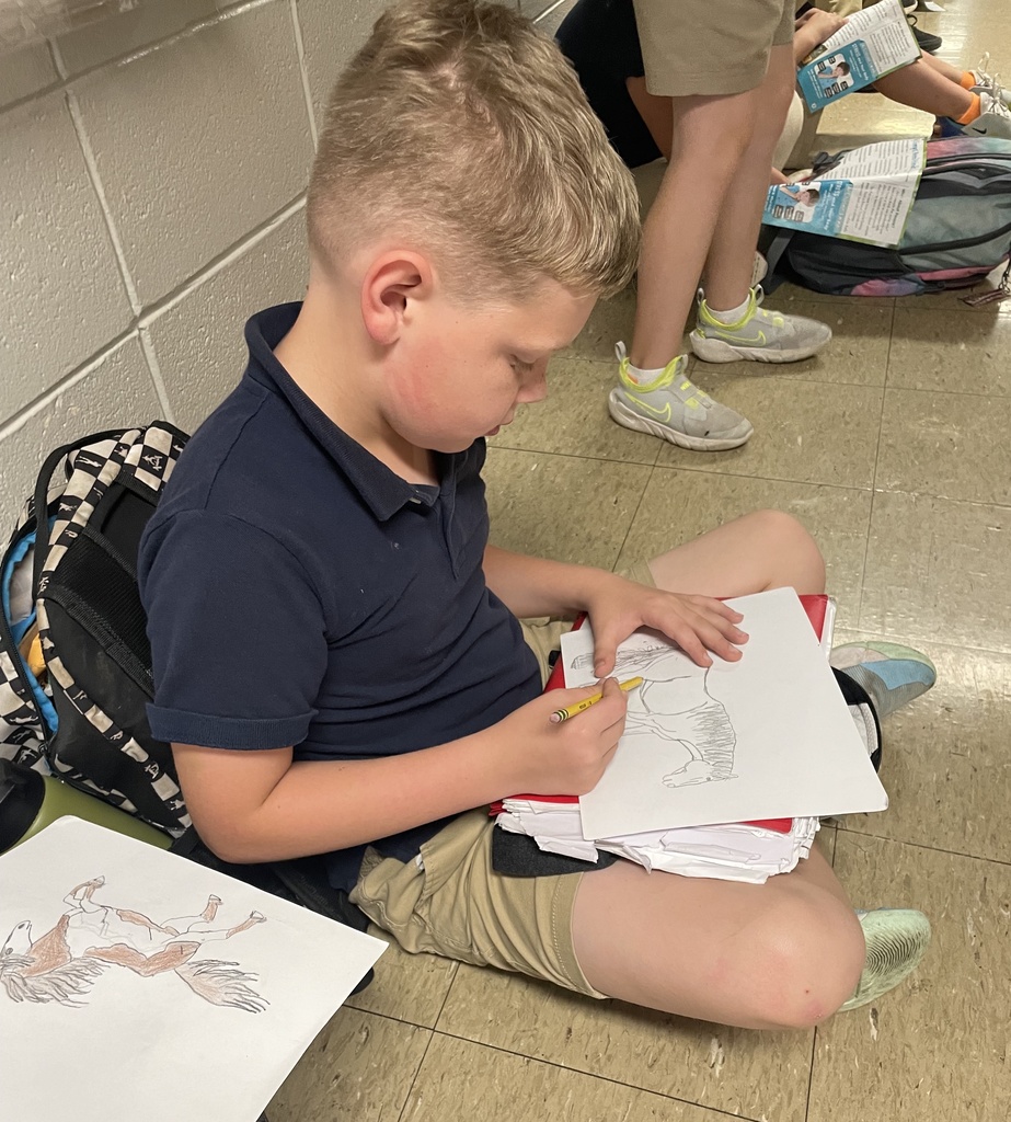 A child sitting on a floor draws a horse.