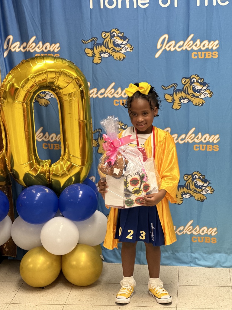 A smiling pre-k student with balloons.