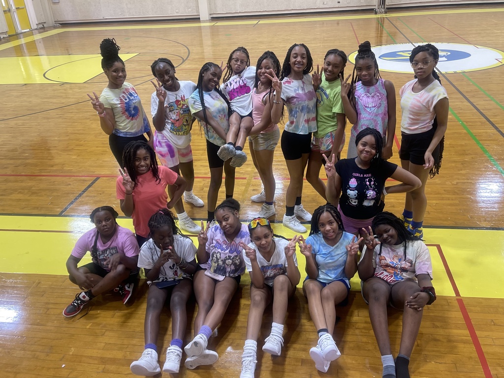 A group of 17 students poses in a gymnasium.