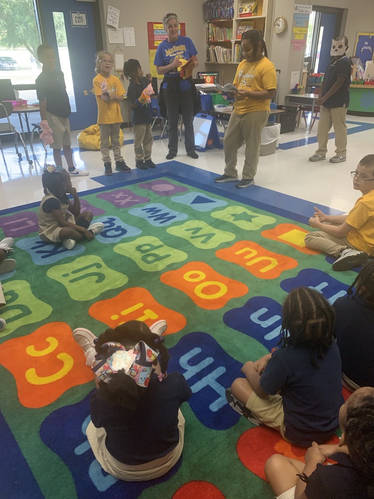A group of older students puts on a puppet show for a group of younger students.