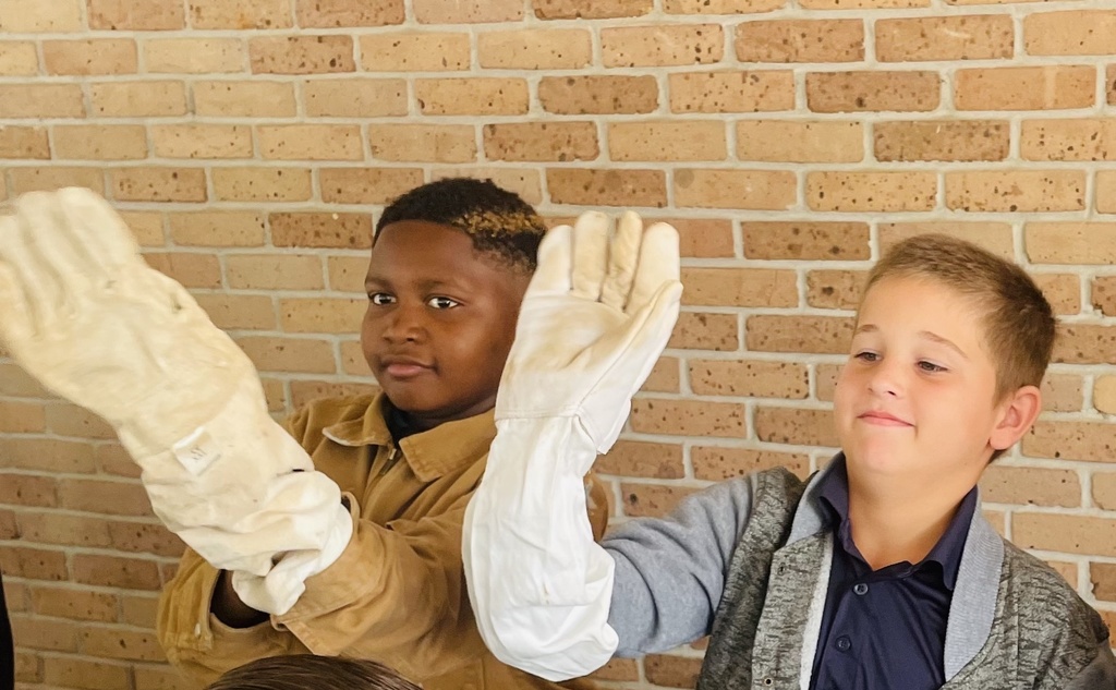 Two children wearing big bee gloves.